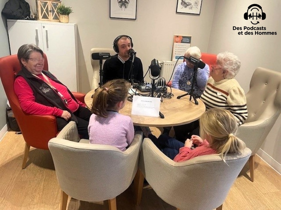 Atelier podcast intergénérationnel : résidentes et enfants autour d'une table avec micros